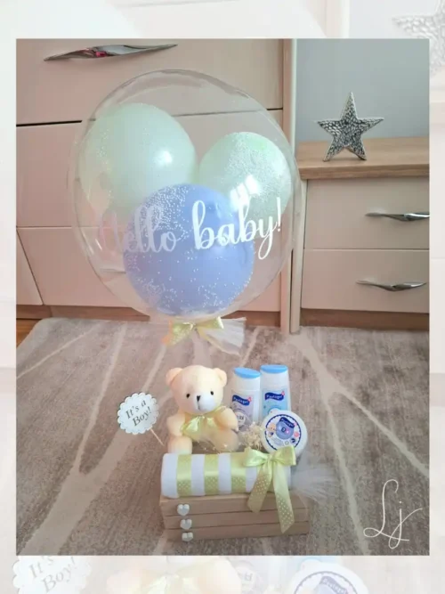 Plavi poklon set za dečaka u drvenoj gajbici sa personalizovanim balonom, plišanim medom i bebi kozmetikom.