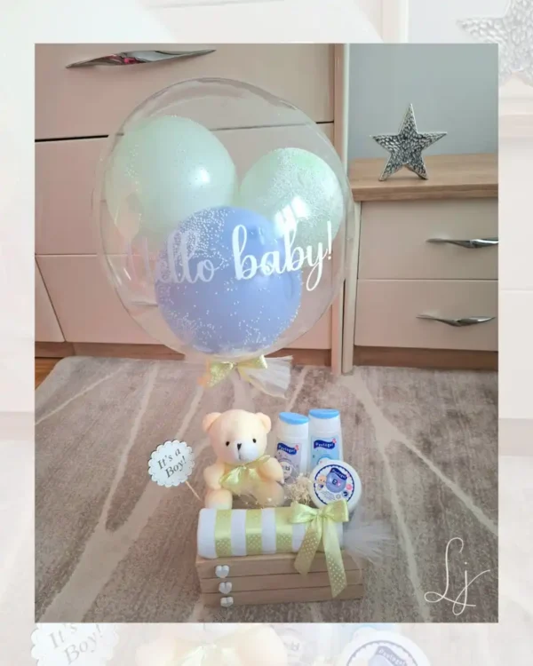 Plavi poklon set za dečaka u drvenoj gajbici sa personalizovanim balonom, plišanim medom i bebi kozmetikom.