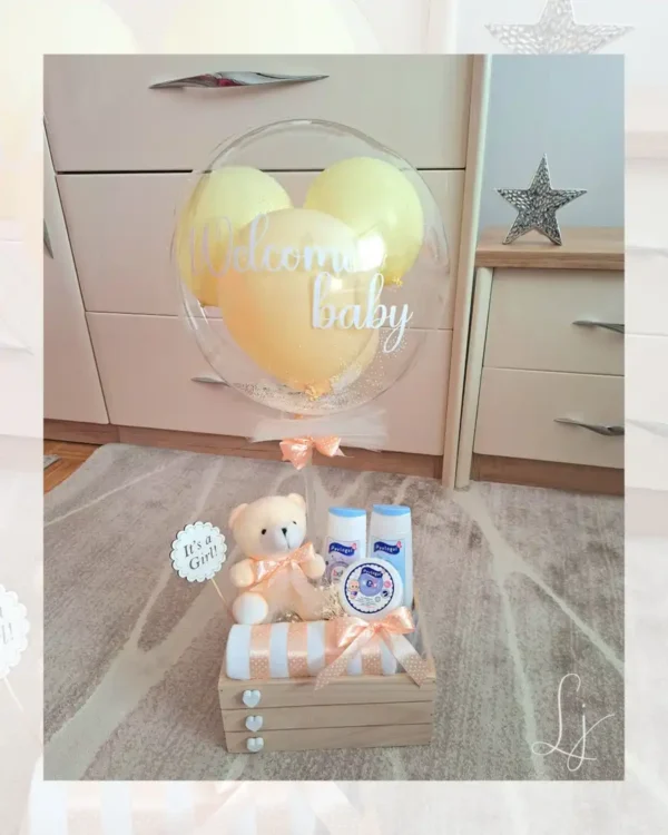 Žuti poklon set za bebe u drvenoj gajbici sa personalizovanim balonom, plišanim medom i dečijom kozmetikom.